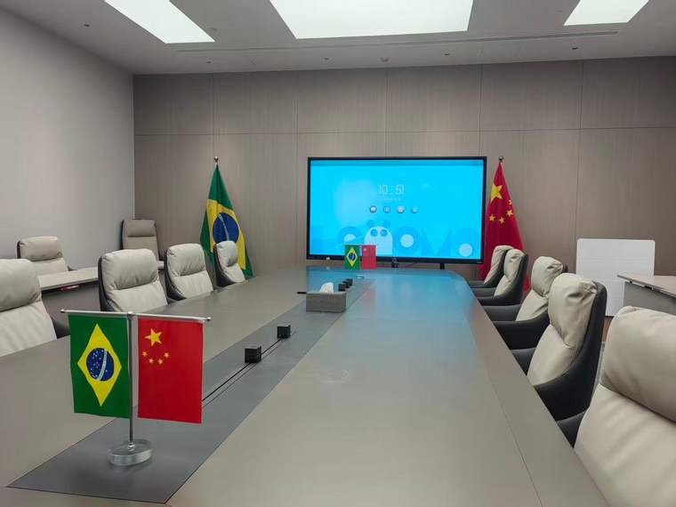 Sala de reuniões institucional com bandeiras do Brasil e da China